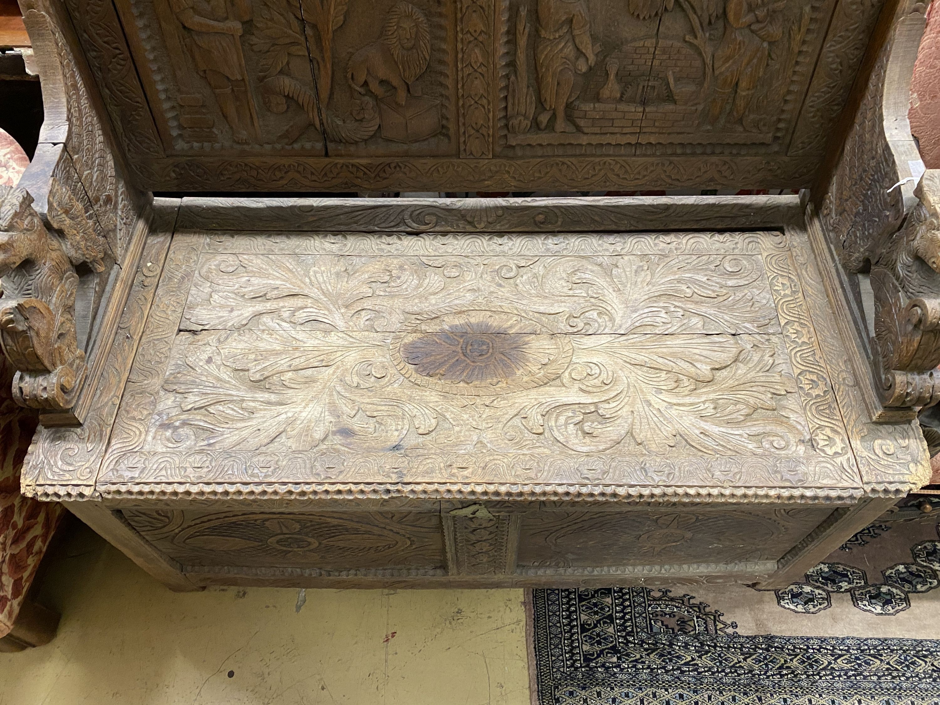 A late 19th century Flemish carved oak settle, length 130cm, depth 58cm, height 118cm